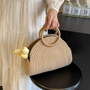 Chic beige woven straw beach bag with round handles and decorative yellow tulips