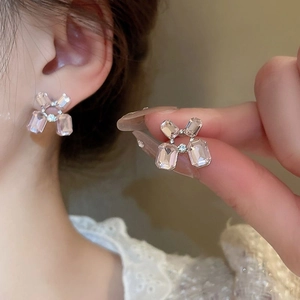 Detailed view of pink crystal balloon dog stud earrings worn on the earlobe
