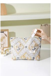 Detail of jacquard makeup bag with floral pattern showing lipstick storage capacity