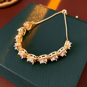 Detailed macro of golden adjustable heart bracelet with zircon inlays on green leather
