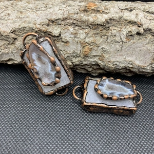 Primer plano de colgantes geoda de ágata vintage con bordes de cobre para hacer joyería