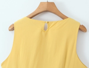 Detail of rear neckline teardrop opening with button on yellow cotton linen dress