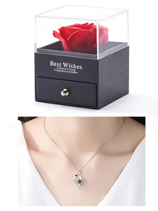 Macro shot of silver heart necklace with black stone in a red rose gift box drawer