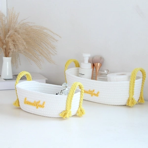 Detail of handwoven white cotton storage basket with yellow tassels and beautiful embroidery