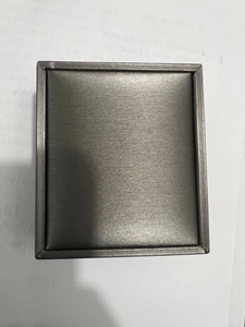 Vista macro di un portagioie rettangolare grigio scuro con finitura in metallo spazzolato