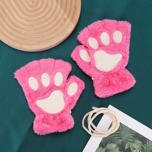 Detail of pink cat paw plush fingerless gloves with cream neck strap on green fabric