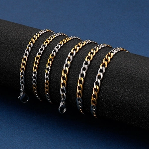 Two-tone gold and silver stainless steel Cuban link bracelets on a display stand
