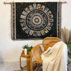 Detail of tarot zodiac cotton tapestry with fringe edges hanging on a white wall