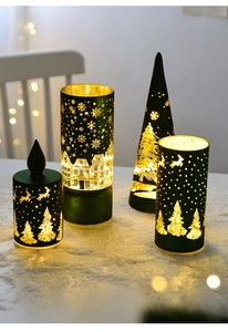 Close-up of dark green Christmas tree tea light holders with snowflake cutouts