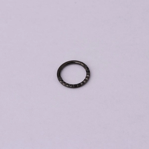 Close-up of black 316 stainless steel circular ring with textured triangle pattern