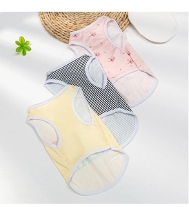 Flat lay of dog summer vests in floral, striped and yellow patterns for small pets