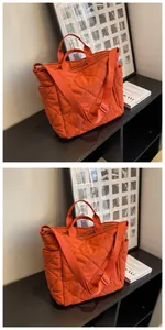 Detail of bright orange quilted tote bag with diamond stitching and adjustable strap
