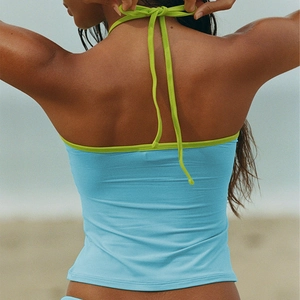 Sky blue halter top with green tie neck detail shown from a back view on a beach