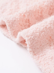 Détail rapproché du tissu en maille florale rose clair avec une texture polaire