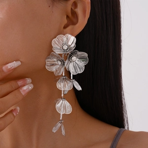 Detail of silver floral earrings with metallic mesh petals and crystal rhinestone center