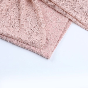Close-up of pink lace fabric texture and intricate floral pattern on the mini dress