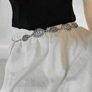 Detail of silver metal waist chain with vintage engraved coins on black dress