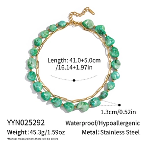 Detail view of irregular green stone necklace with golden stainless steel chain and specs