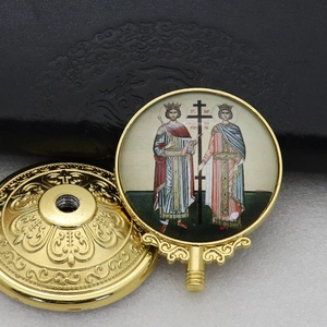 Macro shot of golden religious icon handle featuring detailed embossed metal floral patterns
