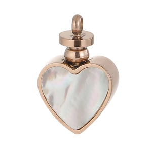 Macro shot of rose gold heart pendant with white shell inlay and threaded screw top
