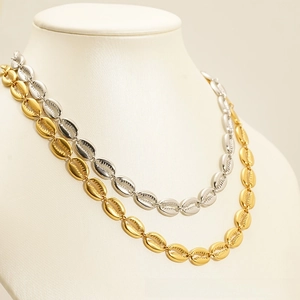 Detail of shell link necklaces featuring textured grooves in gold and silver finish