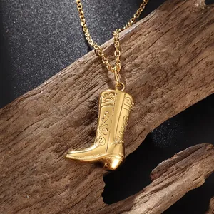 Detailed close-up of a golden cowboy boot pendant with intricate floral engravings