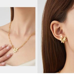 Detail of vintage gold flower necklace and matching earrings set on model neck and ear