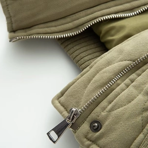 Vue détaillée de la veste vert olive avec fermeture éclair et boutons-pression en métal