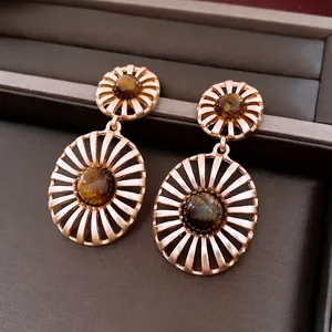Retro hollow golden sunburst earrings with tiger eye stone in a luxury jewelry box