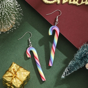Nahaufnahme von Regenbogen-Zuckerstangen-Ohrringen mit festlichen Weihnachts-Requisiten