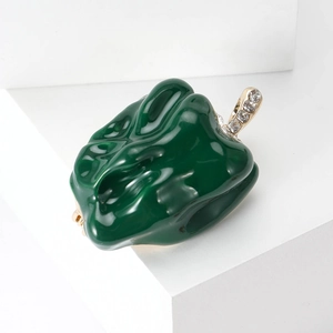 Detail of green enamel chili pepper brooch with gold stem and sparkling crystals