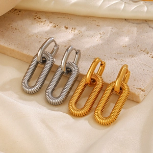 Polished 18K gold and silver intertwined geometric hoop earrings on marble