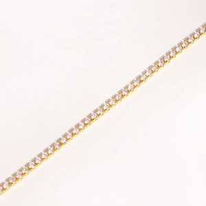 Detail of single row claw-set colorful zircon stones on a gold-plated bracelet