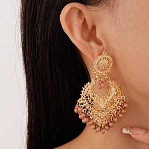 Vintage bohemian gold geometric hollow earrings with dangling beige beaded tassels for women