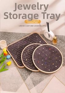 Detailed view of three gold metal jewelry display trays with gray velvet ring inserts