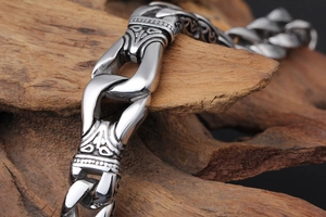 Macro detail of men's vintage stainless steel bracelet with engraved floral patterns