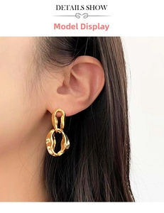 Detail view of gold interlocking hoop earrings with textured lava finish on a model