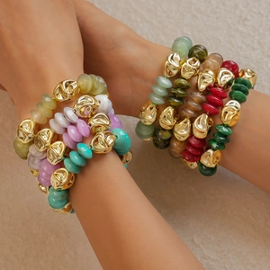 Detailed shot of bohemian style layered acrylic beaded bracelets with gold lava metal beads