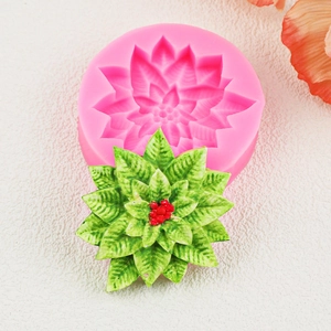 Détail du moule en silicone rose avec décoration de houx vert pour gâteau de Noël