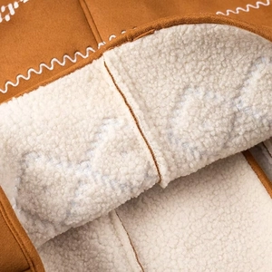 Close-up of brown suede jacket with thick white sherpa lining and wavy stitching details