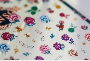 Detailed macro view of 3D embossed floral nail stickers with rose and bee patterns