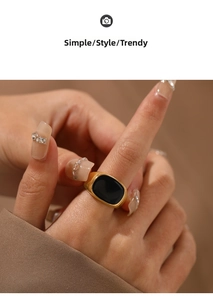 Detail shot of wide gold plated stainless steel ring with a black inlay on model finger