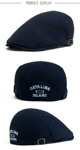 Detail of navy cotton flat cap showing white CATALINA embroidery and metal buckle