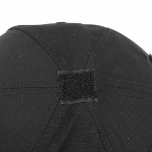 Detailed macro shot of a black tactical cap showing top patch and cotton twill fabric