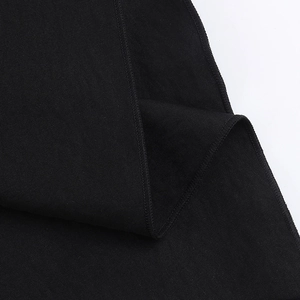Gros plan sur un tissu en maille noir montrant des coutures détaillées et une texture fine