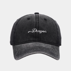 Close-up of Dragon script embroidery on washed denim baseball cap with vintage texture