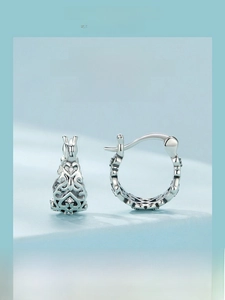 Macro view of vintage 925 sterling silver earrings with hollow pattern and small zircons