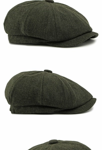 Detailed view of the dark green herringbone wool fabric on a vintage newsboy cap