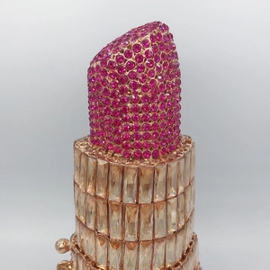 Detail of luxury lipstick-shaped evening clutch with pink and gold rhinestone crystals