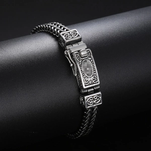 Macro shot of a double-row men's stainless steel chain featuring a Fleur-de-lis clasp